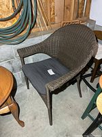 front view of brown resin wicker armchair with gray cushion