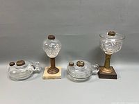Four glass whale oil lamps lined up