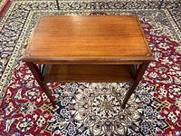 Full view of the table showing top, legs, and lower shelf