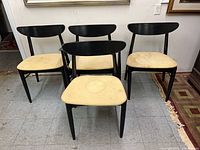 Front view of four black wood dining chairs