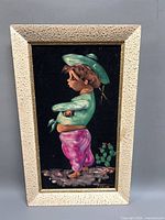 Front view of framed velvet painting showing subject and signature