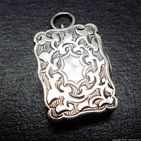 Front view showing engraved scrollwork, scalloped edges, blank cartouche and bale