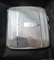 Closed case showing engine-turned exterior and cartouche