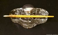 Overall shot of cut glass inkwell with pen resting in trough