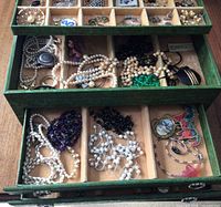 Box open showing top tier compartmentalized tray with assorted jewellery