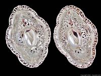 Top view of both Birks sterling silver pierced bonbon dishes showing openwork design and scalloped rims