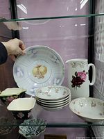 Shelf showing large fruit plate, five small bowls, Japanese bowls, small oval bowl