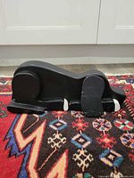 Side view of carved wood dog doorstop showing shape and finish