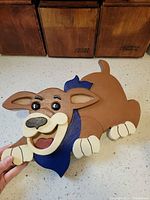 Front view of carved wooden puppy wall décor showing colors and shape