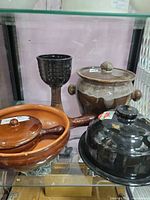 Group view of all four brown ceramic items inside display case
