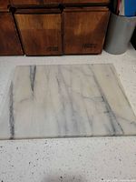 Top view of marble cutting board showing veining and surface wear