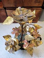 Full view of brass and copper floral sculpture on marble base