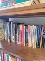 Shelf with row of mixed paperback books, spines visible