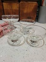 Four clear glass footed dessert bowls grouped together