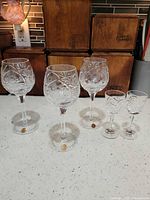 Five clear cut lead crystal stem glasses on countertop