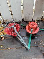 Both vintage metal Christmas tree stands side by side showing overall form and condition