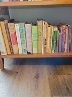 Row of assorted vintage hardcovers and paperbacks on shelf