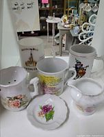 Group shot of three mugs, salt shaker, creamer and trinket dish