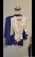 White satin blouse over multicolour geometric blouse on hangers