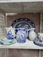 Group view of all six blue and white decorative items displayed on shelf