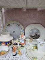 Shelf view showing assorted plates, figurines, creamers and Falcon Ware bowl