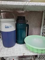 Coleman PolyLite jug, teal thermos, mint green Tupperware gelatin mold on shelf