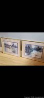 Pair of brass-framed winter landscape prints side by side