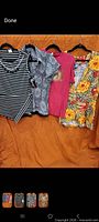 Group shot of four women’s tops on hangers