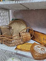 Overview showing wood plaques, wicker basket and tray on shelf