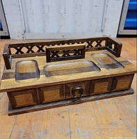 overall view showing wood valet with three top trays, lattice back, drawer front