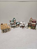 Wide view of four porcelain lighted village buildings