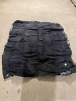 Full view of black flocked inflatable air mattress laid flat