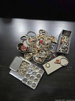 Overview of entire lot on table showing mixed jewelry pile, compartment tray, and boxes