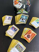 Stacks of assorted Pokémon TCG cards with visible Trainer and Energy cards on tabletop