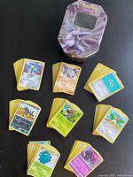 Stacks of Pokémon cards with metal tin visible