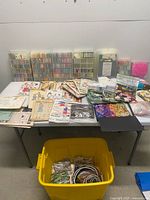 Wide view of table with organizer cases, patterns, floss, hoops in yellow tote
