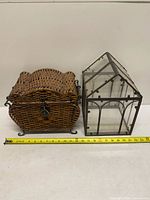 Both wicker chest and glass terrarium side by side with measuring tape for scale