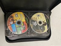 Binder open showing Xbox discs Grand Theft Auto: San Andreas and another title