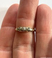 Ring on finger showing top design and two-tone details