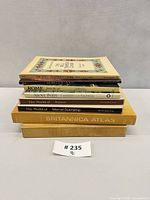 Stack of eight hardcover books showing spines and titles