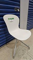 Front angled view of white BoConcept Adelaide swivel chair showing plastic seat and chrome base