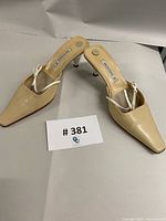 Full view of pair of Bruno Magli pale yellow leather mules with bows