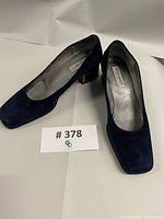 Full view of both shoes showing uppers and heels with lot number card