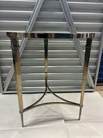 Side view showing nickel frame with square legs and stretcher