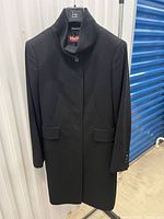 Front view of black MaxMara Studio funnel neck overcoat on hanger