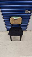 Front view of black wood chair with natural cane backrest