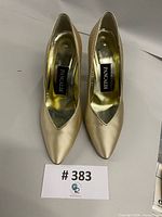 Top view of both metallic gold leather pumps showing pointed toes and Pancaldi insoles