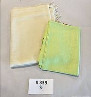 Both scarves folded, yellow and green visible