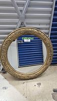 Front view of round ornate gold mirror