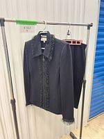 Front view of jacket and skirt hanging on rack